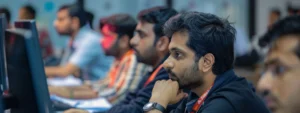 a group of professionals absorbed in intense coding during an aws training session in pune, surrounded by cutting-edge technology.